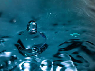 Colorful water drop splash on shiny blue background