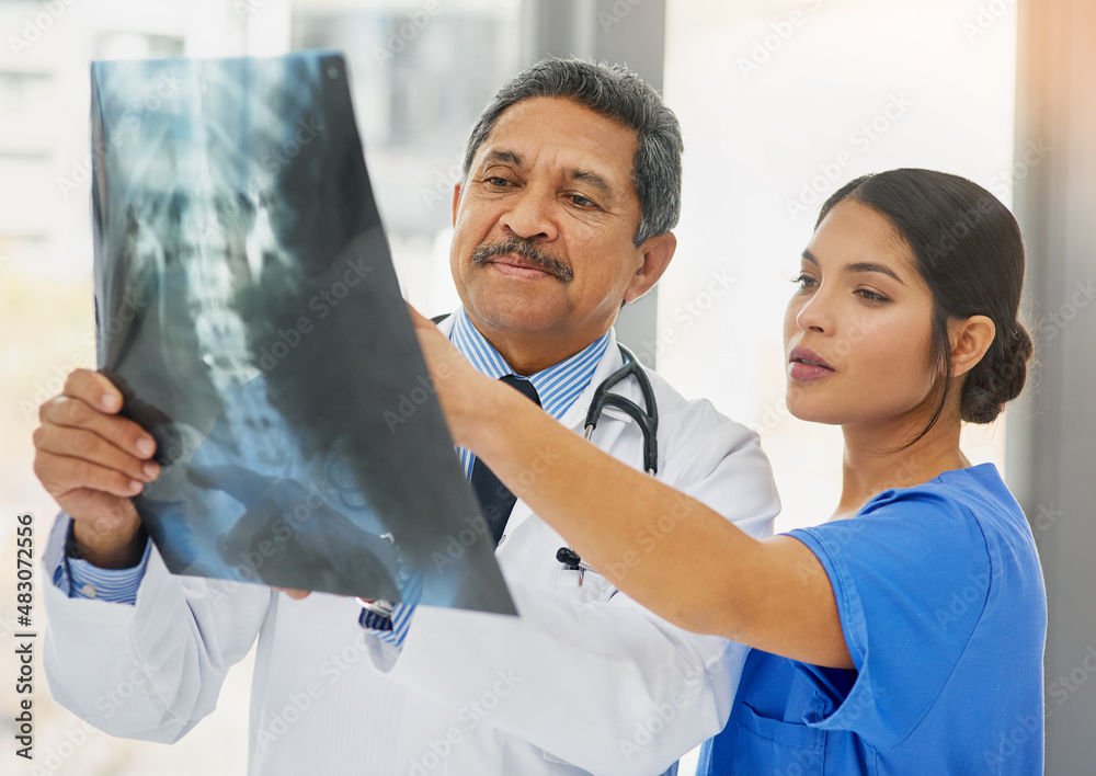 Canvas Prints Seeing right through to the problem. Shot of a mature doctor and young nurse looking at an x ray together.