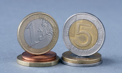 1 euro vs 5 zloty. Coins on a gray background. Increase in the euro exchange rate in relation to the Polish zloty.