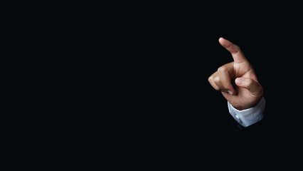 Businessman hand pointing to something or touching a touch screen on black background.