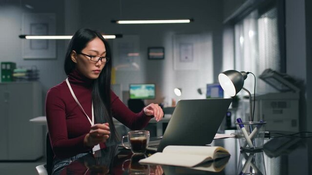Young asian woman working on laptop in modern office. 