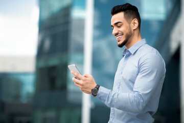Positive arabic businessman with mobile phone outdoors