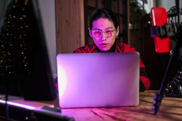 Serious man wearing glasses sitting in front of the laptop and watching inappropriate content - obrazy, fototapety, plakaty
