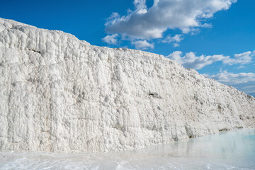 Pamukkale, meaning "cotton castle" in Turkish, is a natural site in Denizli in Turkey. The area is famous for a carbonate mineral left by the flowing of thermal spring water.