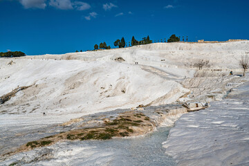 Pamukkale, meaning "cotton castle" in Turkish, is a natural site in Denizli in Turkey. The area is famous for a carbonate mineral left by the flowing of thermal spring water.