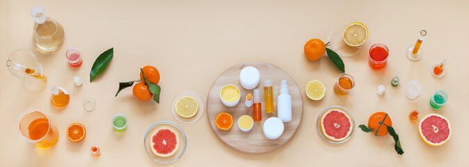 Panoramic top view on laboratory table with chemical glassware and natural cosmetics with citrus extracts on wooden podium. Presentation new cocmetics prodacts. Сoncept of cosmetology research