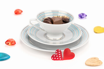 Chocolate candies in a vintage porcelain cup for valentines day on white background