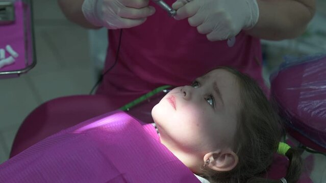 Treatment of baby teeth in a child, a doctor drills a tooth for caries, a visit to the dentist.