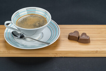Coffee in a vintage porcelain cup and chocolate hearts for valentines day