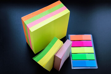 Multicolored paper stickers on black background.
