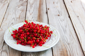 Red currant berry on grey wooden background.