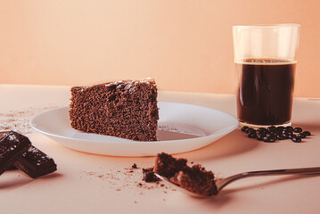 Homemade round sponge cake or chiffon cake on white plate so soft and delicious with ingredients: eggs, flour, milk on wooden table. Homemade bakery for background and wallpaper chocolate cake. 