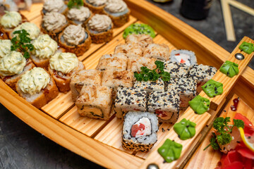 Set of Japanese rolls in a restaurant, substrate in the form of a ship