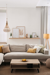 Stylish living room interior with comfortable grey sofa and coffee table