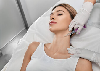 Smoothing female neck skin with injections in neck at cosmetic clinic. Neck skin rejuvenation and contouring, mesotherapy and biorevitalization