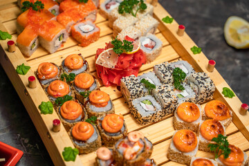 Close-up of baked japanese rolls on a wooden tray, soy sauce, photo for the menu