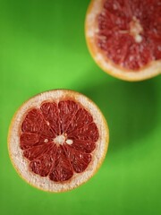 two halves of grapefruit on the green backgroundwith selective focus and copy space