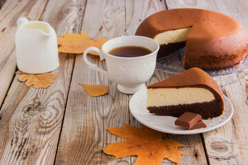 Chocolate-cottage cheese cake and tea on wooden background.