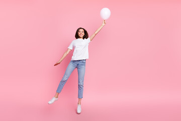 Full size photo of funky carefree female jumping hold birthday decor white balloon isolated on pink color background