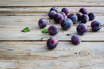 Plums on wooden background.