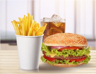 Delicious hamburger with potato fries on a wooden table