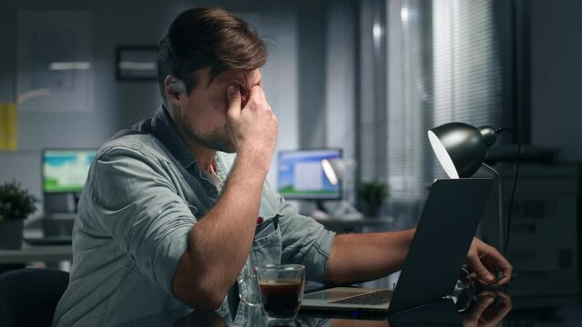 Side view of exhausted caucasian businesswoman working late in office