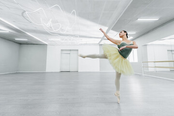 young and slim ballerina rehearsing dance in ballet studio