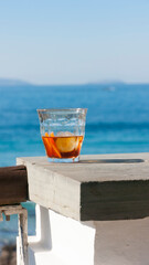 Vaso de vermú en barandilla junto al mar