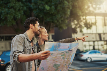 Let curiosity lead the way. Shot of a young couple using a map while exploring the city.