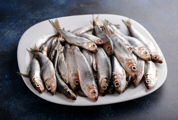 Fresh raw silver herring on a plate.