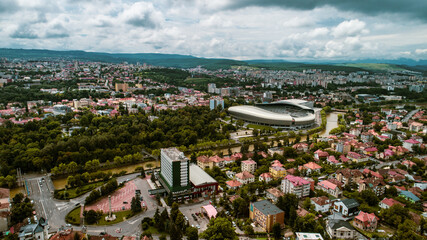 Aerial view of a city park with a river on a cloudy day.