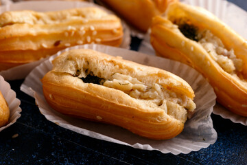 Delicious beautiful dessert profiteroles filled with cheese cream with herbs.