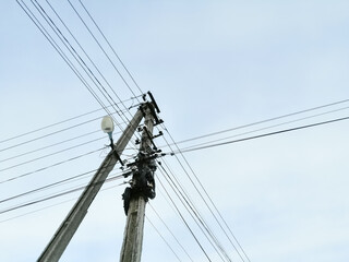 A pole with electrical wires. Power grid. Cable network on a pole. Wires in a mess on a pole.