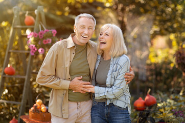 Family lifestyle concept. Happy senior couple walking and laughing at garden outdoors, enjoying...