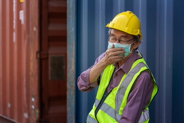 Elderly Asian man wearing a mask works container cargo handling, feeling sick, coughing, sore...