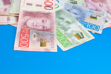 Swedish krona banknotes of different denominations on a blue background - obrazy, fototapety, plakaty