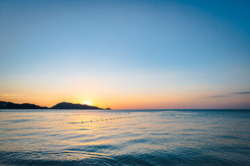 Naklejka premium Patong Beach sunset in Phuket Island, the most popular beach in the resort town of Phuket island, Thailand. Patong beach landscape for vacation, holiday, travel 