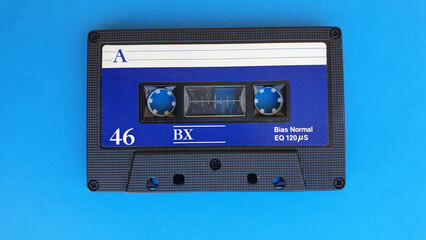 Retro audio cassette tapes on blue background. Vintage media device. Space to write on the label.
