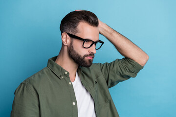 Fototapeta premium Profile photo of confident virile bearded guy hand hair look empty space wear green shirt isolated blue color background