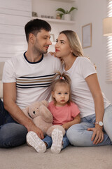 Fototapeta premium Family with little daughter spending time together at home