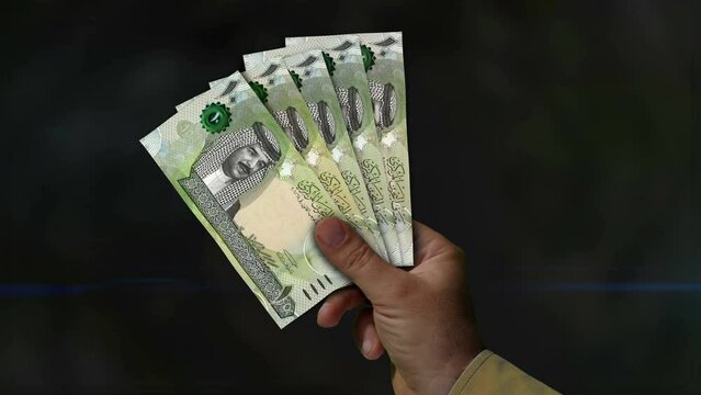 Bahrain Dinar money holding. Fan of banknotes in hand. BHD paper cash. Concept of income, success, business, tax, economy and finance.