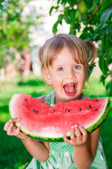 Happy little blonde girl with big slice watermelon in summer time in park, outdoor.