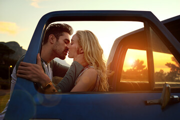His kisses linger on her lips. Shot of an affectionate young couple on a roadtrip. © Anne/peopleimages.com
