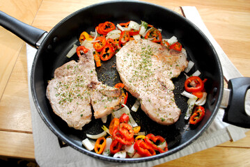 Cooked Pork Chops in a Pan with Onion and Mini Sweet Peppers 