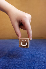 Customer service experience and business satisfaction survey. A hand holding wood block with smiley...