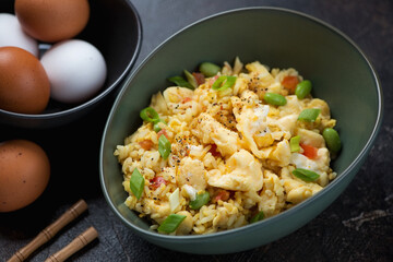 Green bowl with chinese-style egg fried rice, middle close-up, horizontal shot