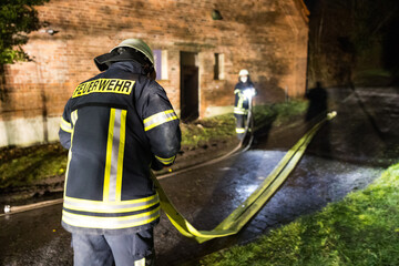 Feuerwehr rollt Schläuche nach einem Einsatz auf