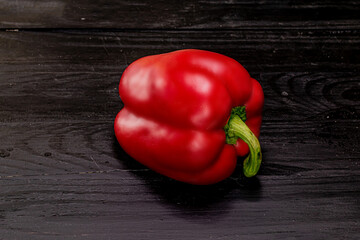 one red pepper on a black background