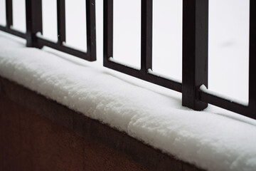 Close-up of the railing on the street covered with snow