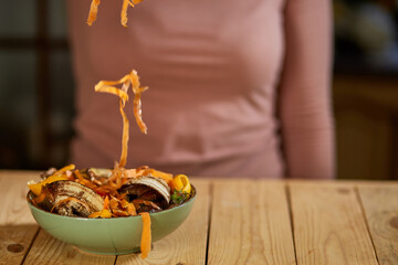 Women scraps peels carrots vegetable peeling, throws in compost bucket, organic composting